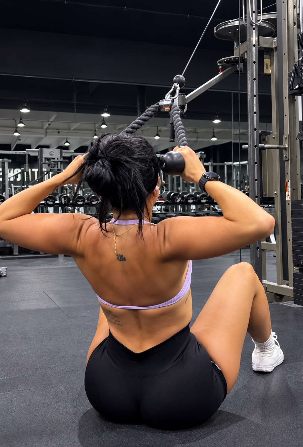 Ariana M. Thompson training with a rope attachment on a gym cable machine